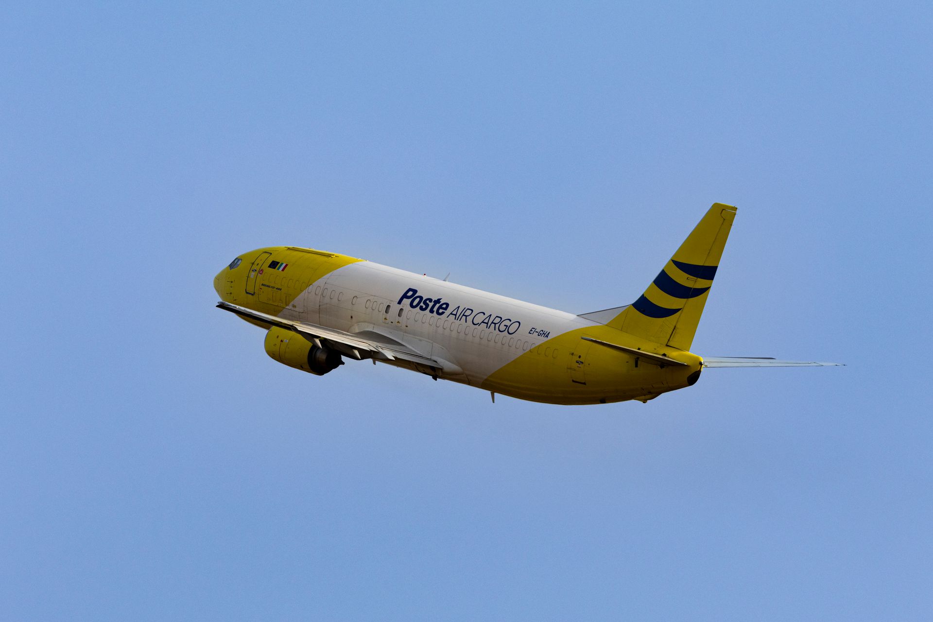 Cargo aircraft climbing into a clear sky